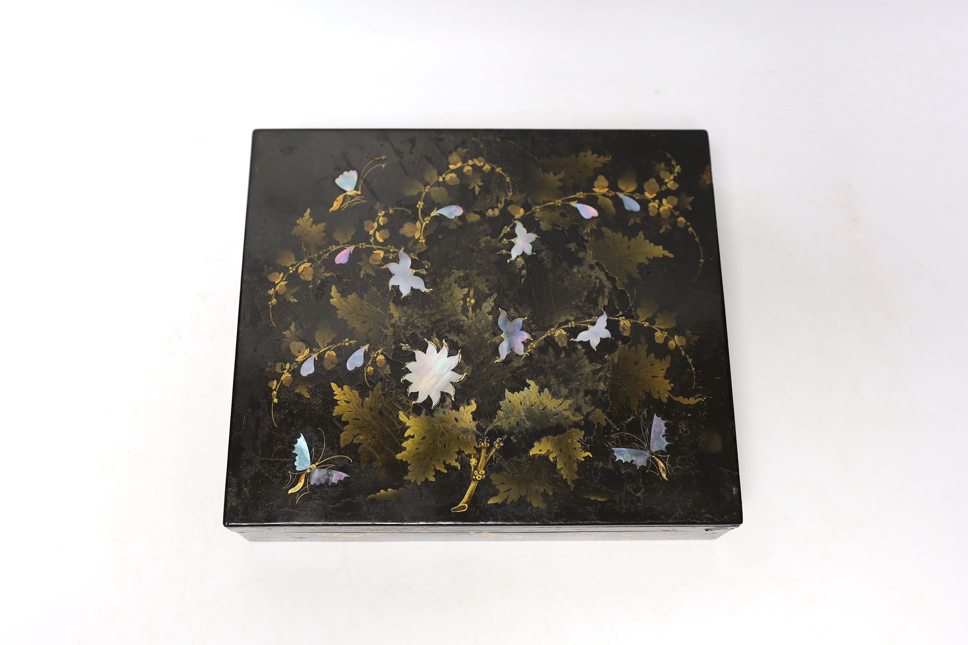 A 19th century lacquer games box with sectional interior and a collection of 49 mother of pearl gaming counters, some armorial, 22 x 19 x 5cm